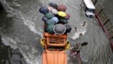 A truckload of stranded commuters cross a flooded street in Manila, Philippines. 