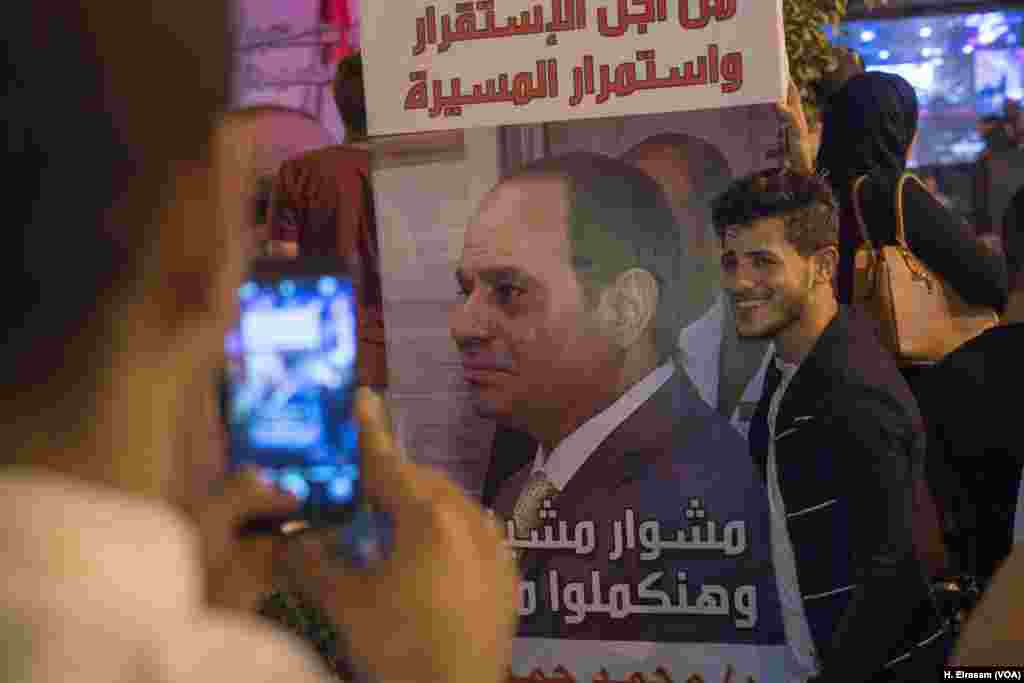 Mohamed Salah posses for a photo with President Abdel-Fattah el-Sissi&rsquo;s poster during a rally, March 20, 2018, in downtown Cairo. &ldquo;I&rsquo;m here to support my country,&rdquo; he said.