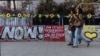 Mujeres caminan junto a un graffiti que apoya la liberación de los rehenes que han sido retenidos en Gaza desde el mortal ataque del 7 de octubre de 2023, en Tel Aviv, Israel, el 18 de febrero de 2025. 