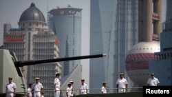 FILE - Crew members of the Australian HMAS Ballarat, ANZAC-class Guided Missile Frigate, stand at attention on the deck as they arrive at a port area of Huangpu River in Shanghai, May 17, 2012. 