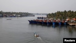 Fishermen travel in a boat in the tributary waters of the Periyar River at Munambam on the outskirts of Kochi in the southern state of Kerala, India, Jan. 21, 2019. 