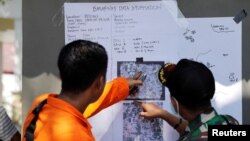 Rescue team members point to a map as they try to recover dead bodies after an earthquake hit Petobo neighborhood in Palu, Indonesia, Oct. 5, 2018.