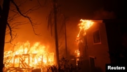 Flames rise from buildings as the Eaton Fire burns in Pasadena, California, Jan. 7, 2025.