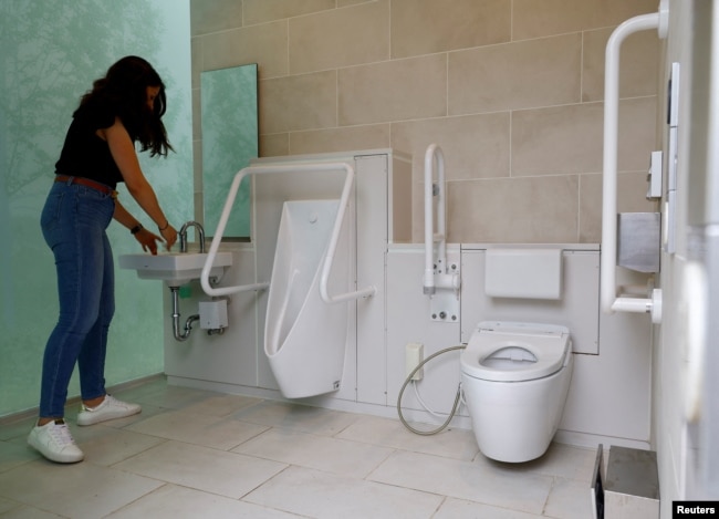 A tourist looks around a public toilet which was redesigned as part of a project to transform public toilets into restrooms that can be used comfortably by everyone, during a Tokyo Toilet Shuttle Tour, at Shibuya ward, in Tokyo, Japan April 4, 2024. (REUTERS/Kim Kyung-Hoon)