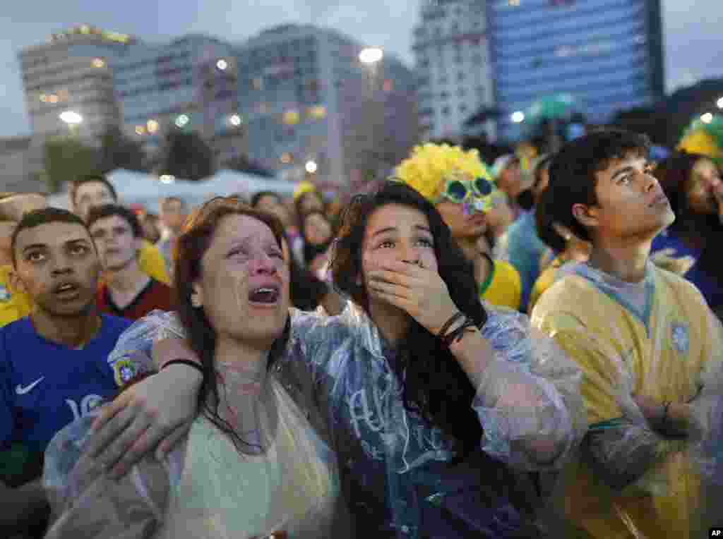 Brazil soccer fans cry as they watch their team lose 7-1 to Germany at a World Cup semifinal match on a live telecast inside the FIFA Fan Fest area on Copacabana beach in Rio de Janeiro, Brazil, July 8, 2014.