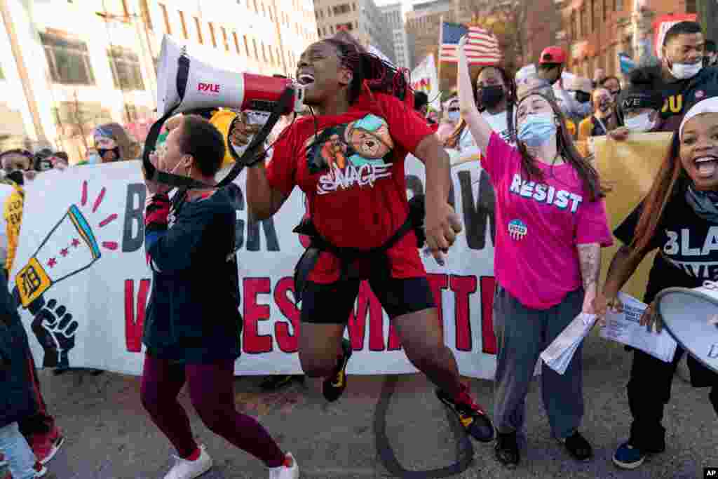 Shaqualla Johnson, holding bullhorn, jumps during a march celebrating the election of Joe Biden as president in Detroit, Michigan, Nov. 7, 2020.
