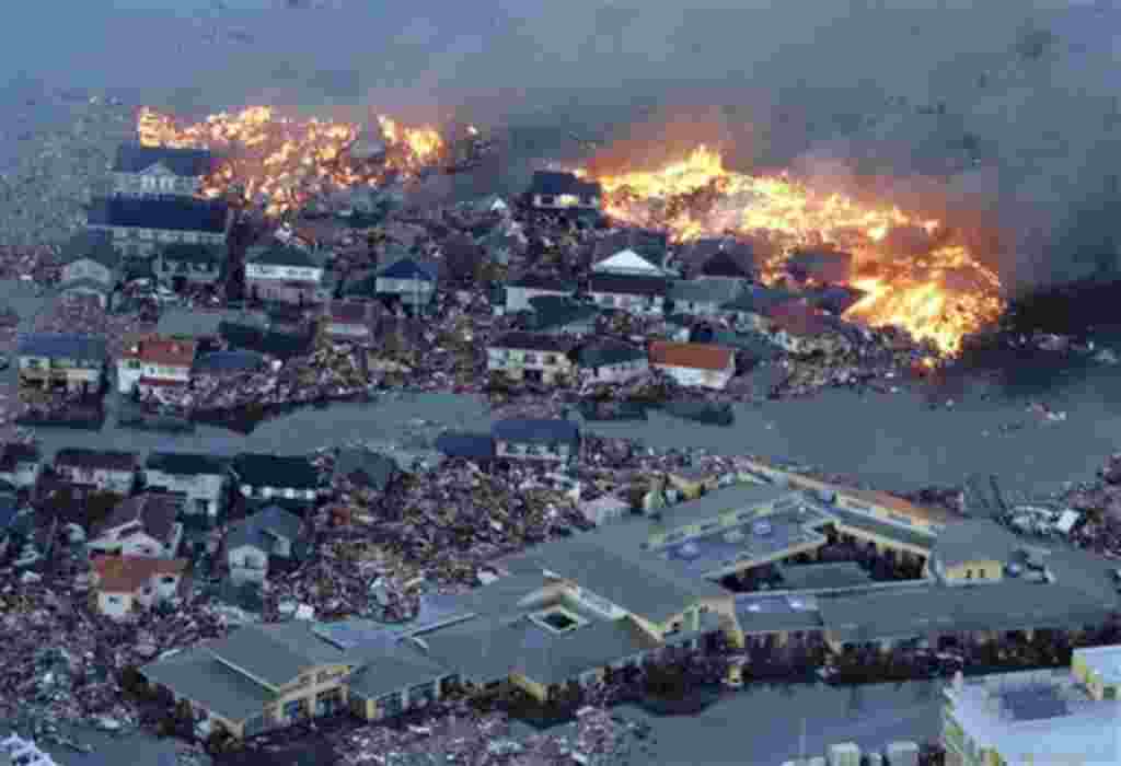 Houses are in flame while the Natori river is flooded over the surrounding area by tsunami tidal waves in Natori city, Miyagi Prefecture, northern Japan, March 11, 2011, after strong earthquakes hit the area. (AP Photo/Yasushi Kanno, The Yomiuri Shimbun) 