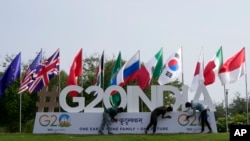 2023 年 7 月 13 日，在印度古吉拉特邦首府甘地讷格尔，工人们赶在G20峰会的一个工作组会议前安装峰会的标志。