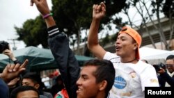 Migrantes centroamericanos de una caravana que llegó a la frontera entre México y Estados Unidos; saludan la noticia de la primera persona que logró ingresar a territorio estadounidense para pedir asilo. Lunes 30 de abril de 2018.