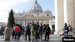 FILE - Tourists pass through security screenings as they enter the Vatican in Rome, Italy, Nov. 22, 2015. 