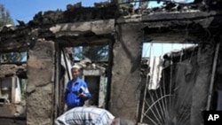 ຊາຍ Uzbek ຄົນນຶ່ງເອົາມືກຸມຫົວ ດ້ວຍຄວາມເສຍໃຈແລະສິ້ນຫວັງ ຢູ່ທາງຂ້າງເຮືອນຂອງລາວ ທ່ີຖືກໄຟໄໝ້ ວັນທີ 14 ມິຖຸນາ 2010