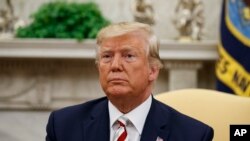 President Donald Trump pauses while speaking during a meeting with Romanian President Klaus Iohannis in the Oval Office of the White House, Aug. 20, 2019, in Washington.