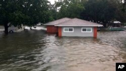 FILE - In this photo provided by the Chambers County Sheriff's Office, floodwaters surround a home, Sept 19, 2019, in Winnie, Texas. The area experienced heavy flooding due to Tropical Storm Imelda.