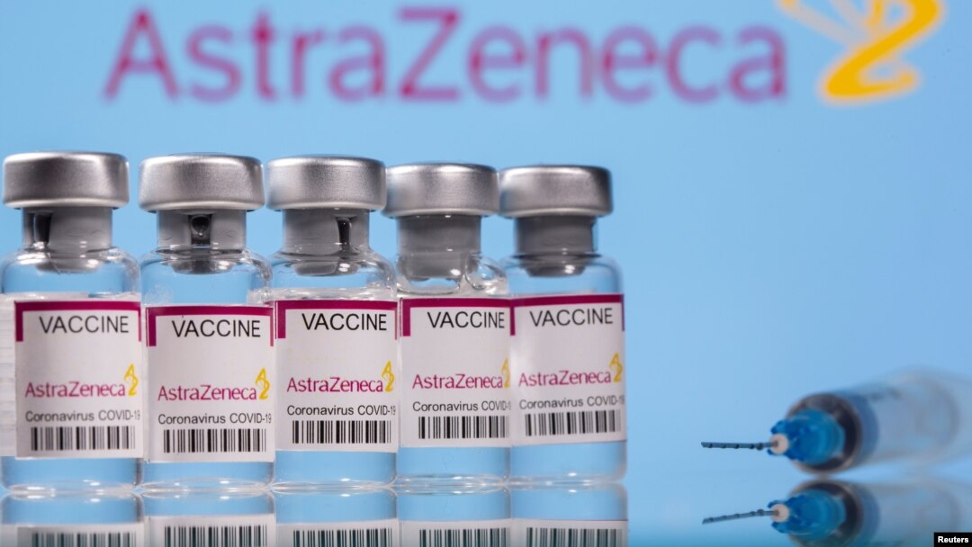 Jajaran ampul bertuliskan "Vaksin COVID-19 Astra Zeneca" dan sebuah suntikan di depan logo AstraZeneca, Minggu, 14 Maret 2021.