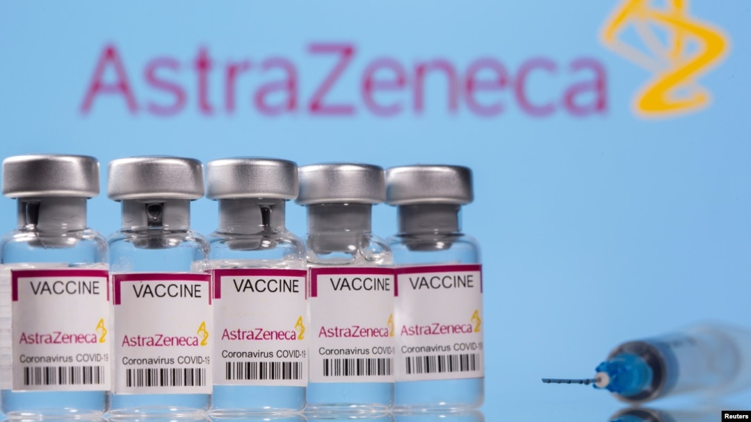 Vials labelled "Astra Zeneca COVID-19 Coronavirus Vaccine" and a syringe are seen in front of a displayed AstraZeneca logo, in this illustration photo taken March 14, 2021.
