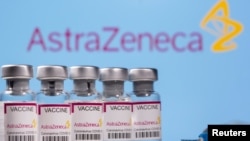 Vials labelled "Astra Zeneca COVID-19 Coronavirus Vaccine" and a syringe are seen in front of a displayed AstraZeneca logo, in this illustration photo taken March 14, 2021.