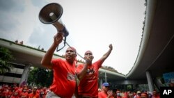 Para pemrotes pro-pemerintah berkaos merah, meneriakkan slogan dalam aksi demo mendukung PM Najib Razak di Kuala Lumpur, Malaysia (16/9).