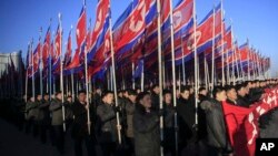 FILE - North Koreans parade with the North Korean flag in Kim Il Sung Square in Pyongyang, North Korea, Thursday, Feb. 25, 2016, to show their loyalty to the Workers' Party. 