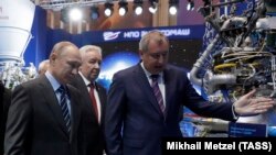 RUSSIA -- Russian President Vladimir Putin and Roskosmos head Dmitry Rogozin (right) visit the state company that produces Proton rocket engines, in Moscow, April 12, 2019.