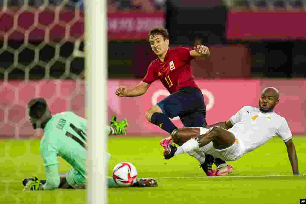 Spain&#39;s Mikel Oyarzabal takes a shot as Ivory Coast&#39;s Kouadio-Yves Dabila fails to block in a men&#39;s quarterfinal soccer match at the 2020 Summer Olympics, Saturday, July 31, 2021, in Rifu, Japan, Tokyo. (AP Photo/Andre Penner)