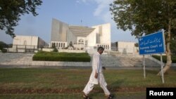 Seorang pria melintasi gedung Mahkamah Agung Pakistan di Islamabad (Foto: dok). MA Pakistan telah memanggil PM Raja Pervez Ashraf atas tuduhan tidak mengindahkan perintah MA untuk membuka kembali kasus korupsi yang dituduhkan atas Presiden Zardari. 