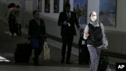 지난 15일 미국 뉴저지 소재 뉴어크 리버티 국제공항에서 여성이 신종 코로나바이러스 감염증(COVID-19) 방지를 위해 마스크를 착용하고 있다. 