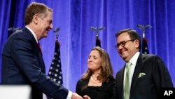 U.S. Trade Representative Robert Lighthizer, left, shakes hands with Mexico's Secretary of Economy Ildefonso Guajardo Villarreal, accompanied by Canadian Foreign Affairs Minister Chrystia Freeland, after attending a news conference at the start of NAFTA Renegotiations in Washington, Aug. 16, 2017. 