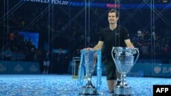 Petenis Inggris, Andy Murray, berpose dengan trofi Nomor Satu Dunia ATP dan trofi Final Tur Dunia setelah memenangkan laga final tunggal putra melawan petenis Serbia, Novak Djokovic, di London, 20 November 2016.