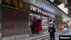 A person walks past a shop closed for business, after the government eased curbs on the COVID-19 control, in Wuhan, China Dec. 10, 2022. 
