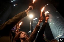 Demonstrators clasp  torches arsenic  they stitchery  during a protestation  calling for the merchandise  of each  hostages held captive by Hamas successful  the Gaza Strip, successful  Tel Aviv, Israel connected  Jan. 18, 2025.