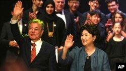 Presiden Korea Selatan Moon Jae-in, kiri, melambai ke arah kerumunan pengunjung bersama istrinya, Kim Jung-sook, di Abu Dhabi, United Emirates Arab, 26 Maret 2018. 