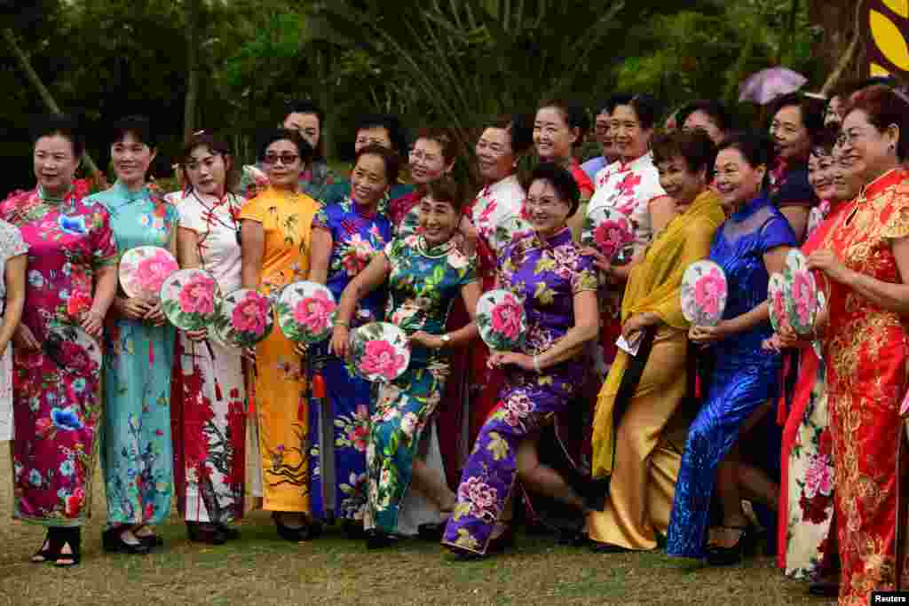 中国海南省琼海，国际妇女节前夕，旗袍秀中的妇女摆姿势拍照。（2018年3月7日）