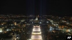 The U.S. Capitol building is prepared for the inauguration ceremonies for President-elect Joe Biden as the &quot;Field of Flags&quot; are illuminated on the ground on the National Mall, Jan. 18, 2021. in Washington, D.C.