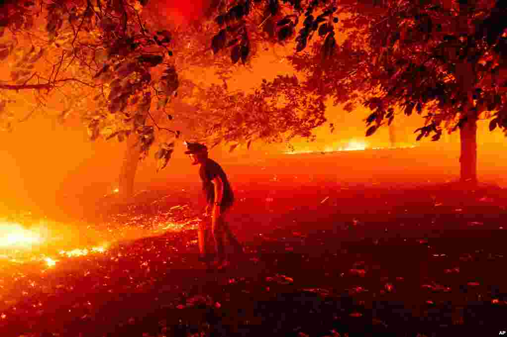 Matt Nichols tries to save his home as the LNU Lightning Complex fires tear through Vacaville, California. Fire crews across the region scrambled to contain dozens of wildfires sparked by lightning strikes as a statewide heat wave continues.