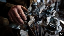 Viktor Mikhalev turned weapons and ammunitions to roses at a workshop in his house in Donetsk, Russian-controlled Donetsk area. (AP Photo/Alexei Alexandrov)