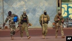 FILE - This undated photograph provided by the French military shows three Russian mercenaries, in northern Mali.