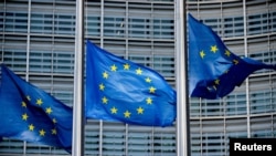 FILE PHOTO: European Union flags fly outside the European Commission headquarters in Brussels