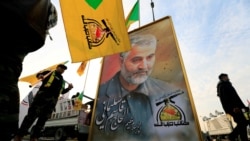 FILE PHOTO: Kataib Hezbollah Iraqi militia hold the picture of the Iranian Major-General Qassem Soleimani, as they gather ahead of the funeral of the Iraqi militia commander Abu Mahdi al-Muhandis, in Baghdad.