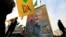 FILE PHOTO: Kataib Hezbollah Iraqi militia hold the picture of the Iranian Major-General Qassem Soleimani, as they gather ahead of the funeral of the Iraqi militia commander Abu Mahdi al-Muhandis, in Baghdad.