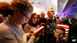 People check election returns on their phones at the election night party for Conor Lamb, the Democratic candidate for the March 13 special election in Pennsylvania's 18th Congressional District, on Canonsburg, Pa., Tuesday, March 13, 2018. (AP Photo)