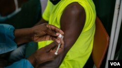 A Zimbabwean receives a COVID-19 vaccine jab at Wilkins Hospital - Zimbabwe’s main vaccination center in Harare on May 12, 2021 when things were still on course. Then shortages began. (Columbus Mavhunga/VOA)