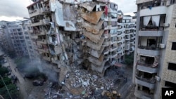 Bulldozers remove the rubble of a destroyed building that was hit Sunday night in an Israeli airstrike in Dahiyeh, in the southern suburb of Beirut, Lebanon, Nov. 25, 2024. 