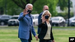 President Joe Biden with first lady Jill Biden wave as they walk on the Ellipse near the White House after spending the weekend in Wilmington, Del., April 25, 2021, in Washington. 