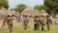 Police officers stand guard following a fresh attack at Kipao village in Tana River district in Kenya's coastal Tana Delta region, December 22, 2012.