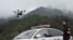 FILE - A police officer of the Forest Public Security Bureau operates a drone in Lishui, Zhejiang province, China, April 4, 2018. Police in China used drones to track down a fugitive who had escaped from a prison camp 17 years ago.