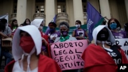 Un manifestante sostiene un cartel que dice en portugués "aborto legal, seguro, gratuito" durante una manifestación que marca el "Día por la despenalización del aborto en América Latina y el Caribe", en Río de Janeiro, Brasil. el 28 de septiembre de 2020.