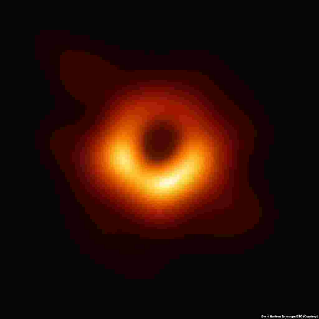 Первый снимок черной дыры, 10 апреля 2019 Один из самых обсуждаемых снимков 2019 года - первая в истории фотография черной дыры, расположенной в самом центре галактики M87. На снимке изображена тень сверхмассивной черной дыры колоссальных размеров - около 100 млрд километров в диаметре. Ее масса превышает 6,5 млрд масс Солнца. 📸: Event Horizon Telescope/ESO