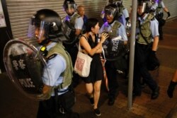Policemen push a woman as they clear a street during a protest in Hong Kong, July 7, 2019.