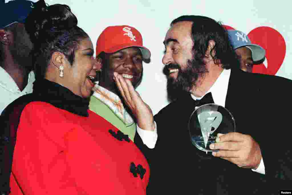 Singer Luciano Pavarotti gestures towards singer Aretha Franklin during a photo opportunity at the 1998 MusiCares benefit dinner in New York, Feb. 23, 1998.