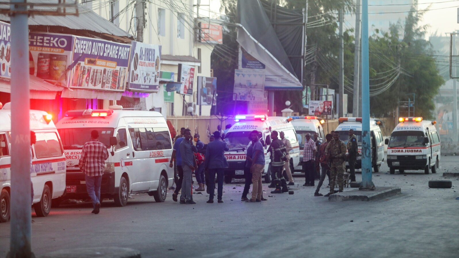 Bezbednosne snage Somalije obezbeđuju mesto eksplozije automobila bombe, dok vozila hitne pomoći čekaju kako bi se ukazala ponoć povređenima u oblasti poznatoj kao Četvrti kilometar u Mogadišu, Somalija, 31. januara 2021. (RojtersS/Feisal Omar)